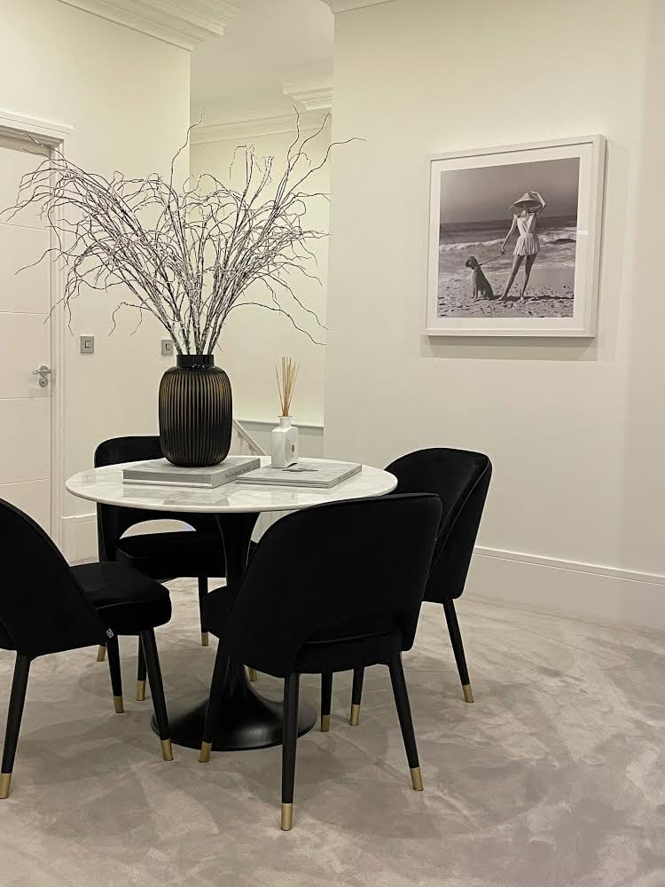 Soft pale carpet fitted around a marble dining table and dark chairs