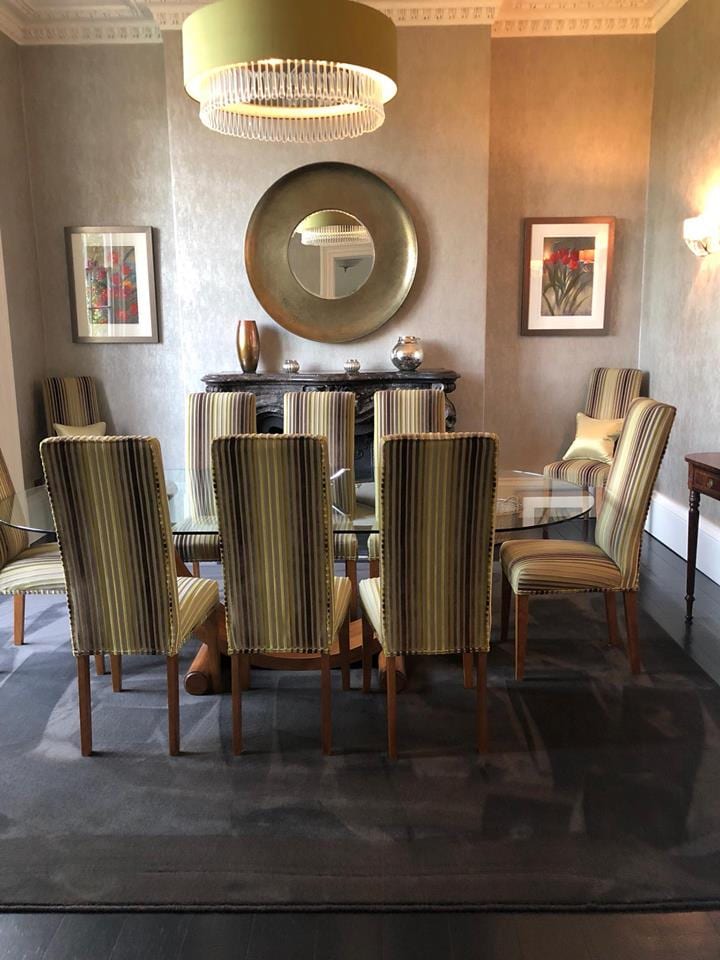 Dark carpet throughout a dining room with striped upholstered chairs